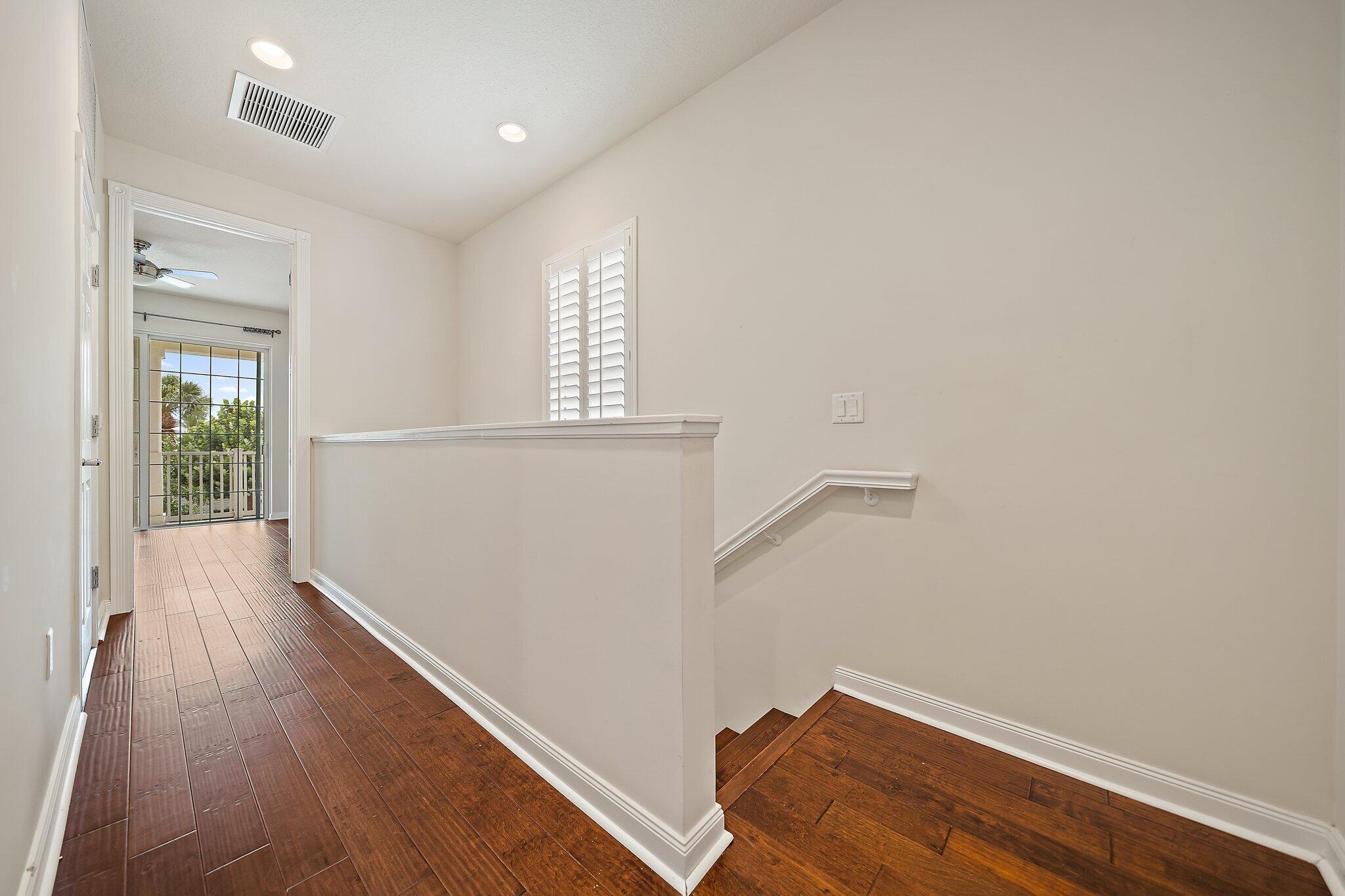 3253 Duncombe Drive Jupiter, FL 33458 - Photo 13 of 33 a view of hallway with window and wooden floor