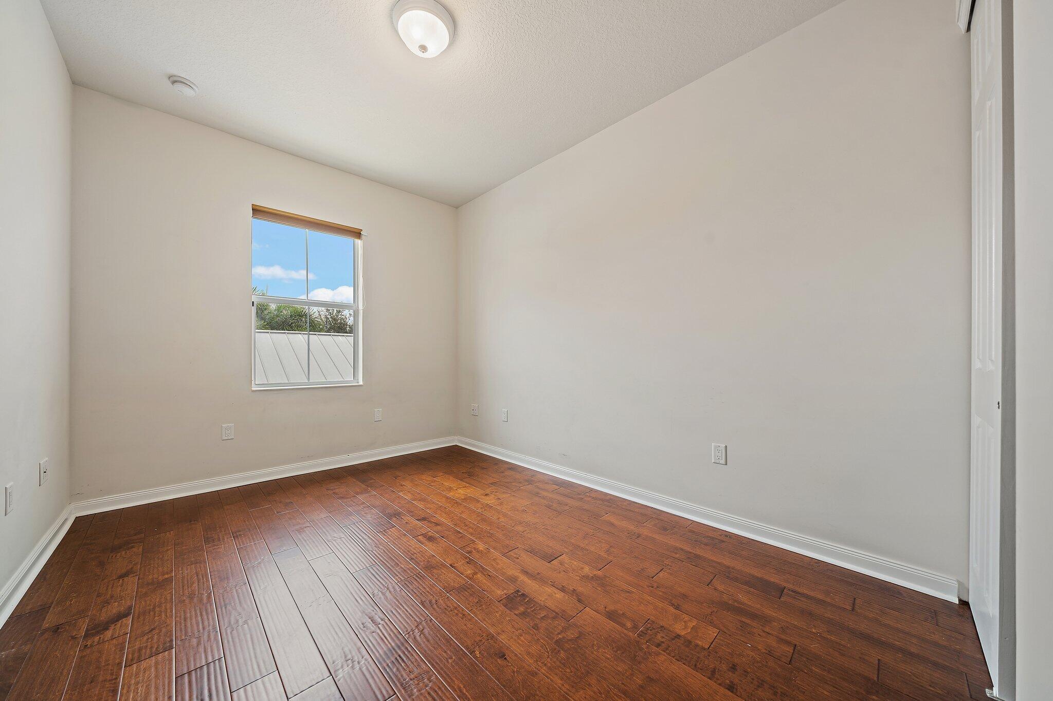 3253 Duncombe Drive Jupiter, FL 33458 - Photo 21 of 33 an empty room with wooden floor and windows
