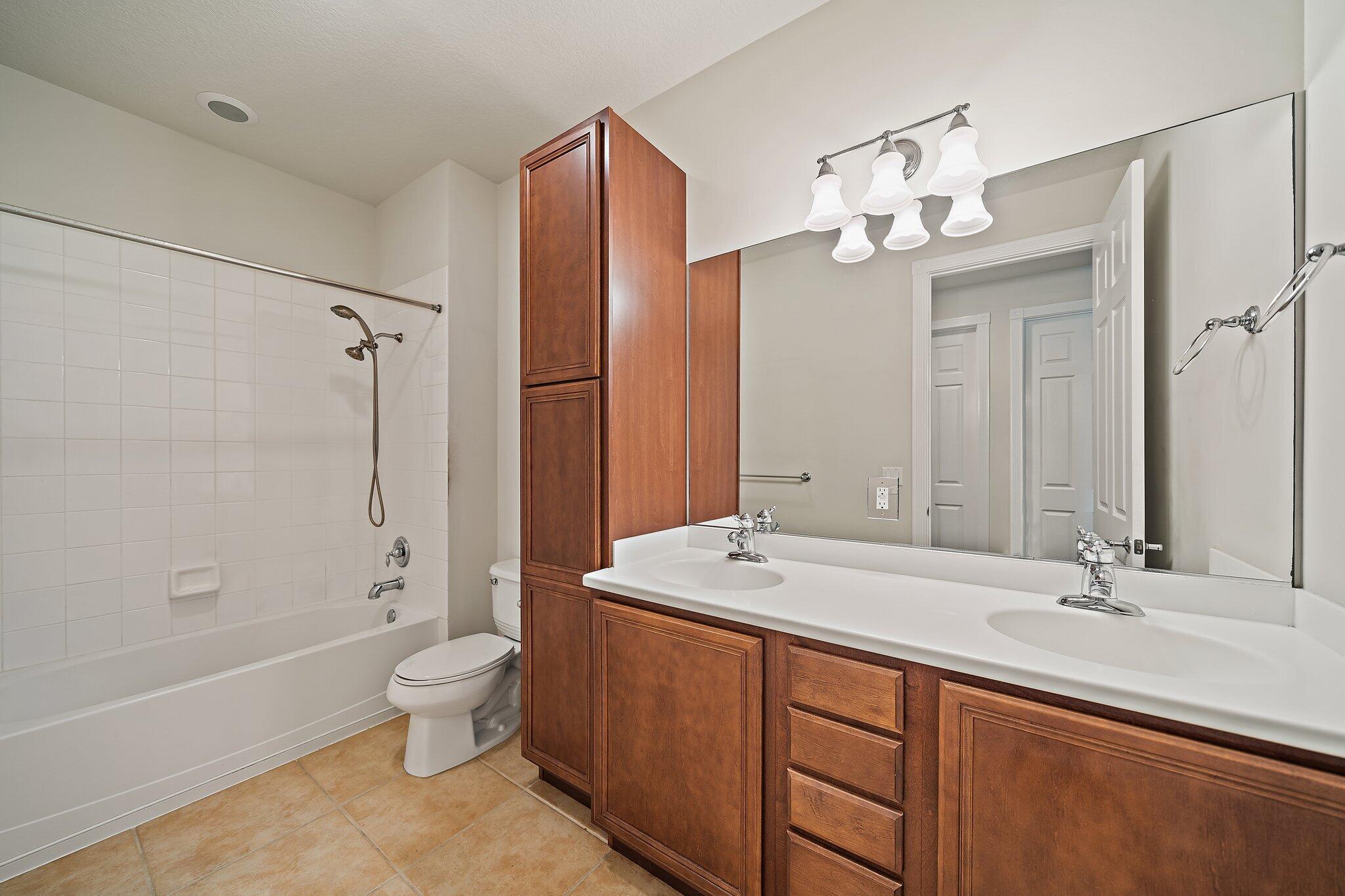 3253 Duncombe Drive Jupiter, FL 33458 - Photo 23 of 33 a bathroom with a double vanity sink mirror double and bathtub