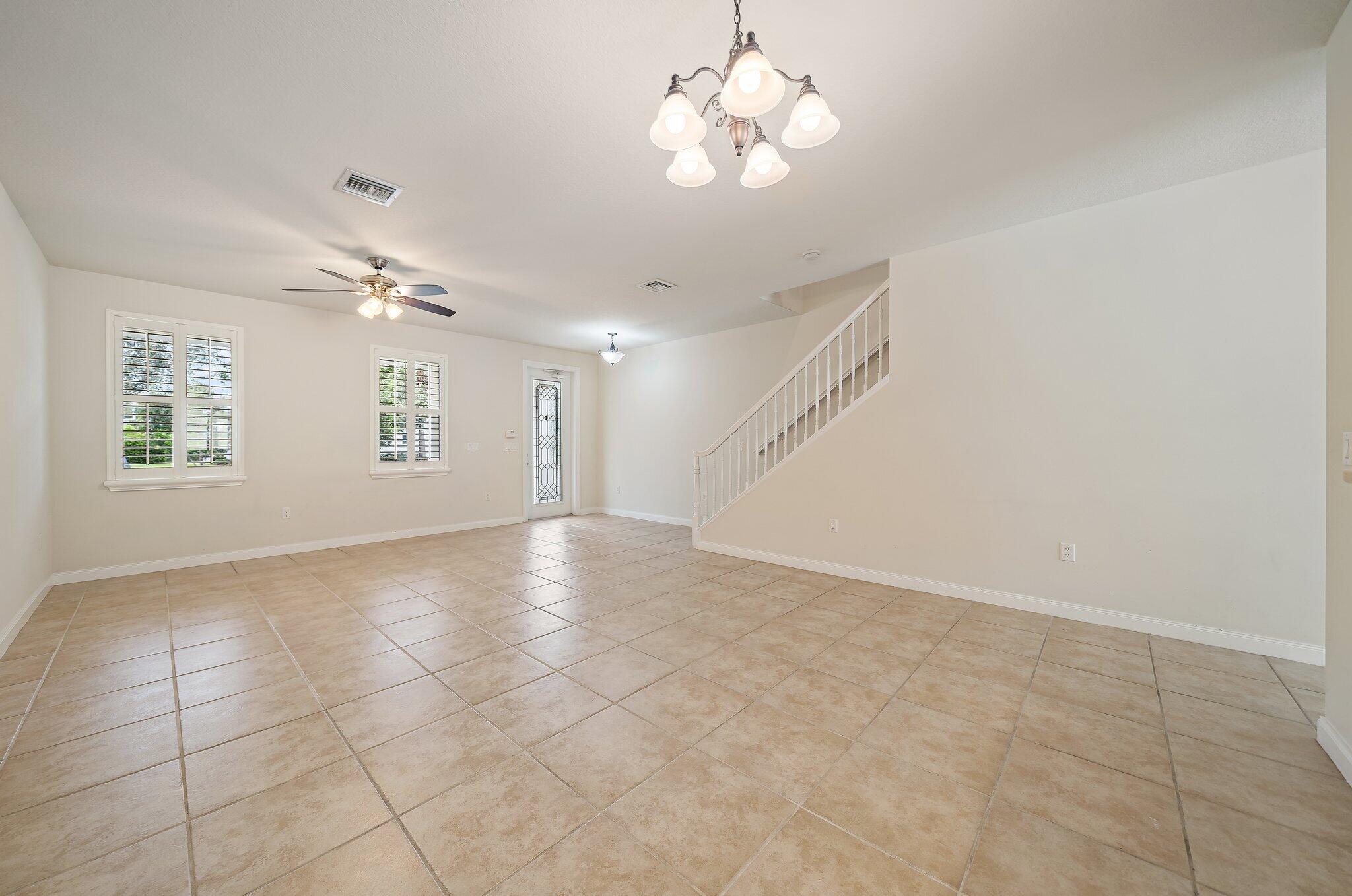 3253 Duncombe Drive Jupiter, FL 33458 - Photo 6 of 33 an empty room with windows and ceiling fan