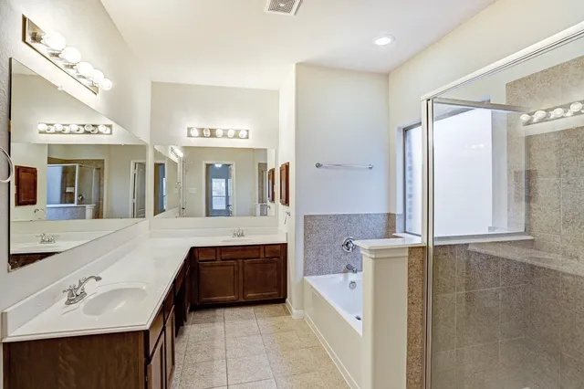 a spacious bathroom with a bathtub sink and mirror