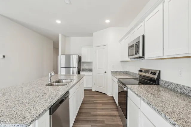 a kitchen with stainless steel appliances granite countertop a sink stove and refrigerator