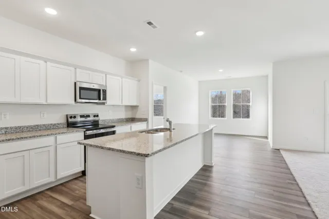 a kitchen with stainless steel appliances granite countertop a sink stove and microwave