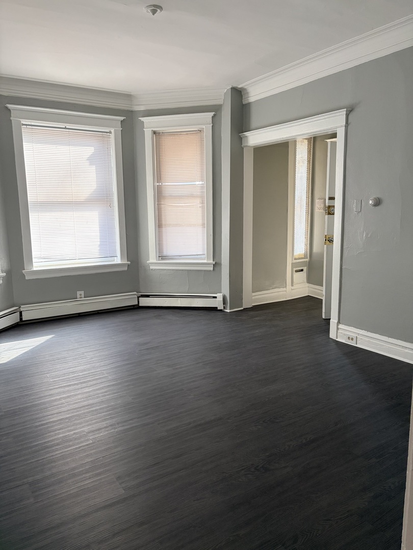 7700 South Green Street, Unit 1 Chicago, IL 60620 - Photo 2 of 11 an empty room with wooden floor and windows