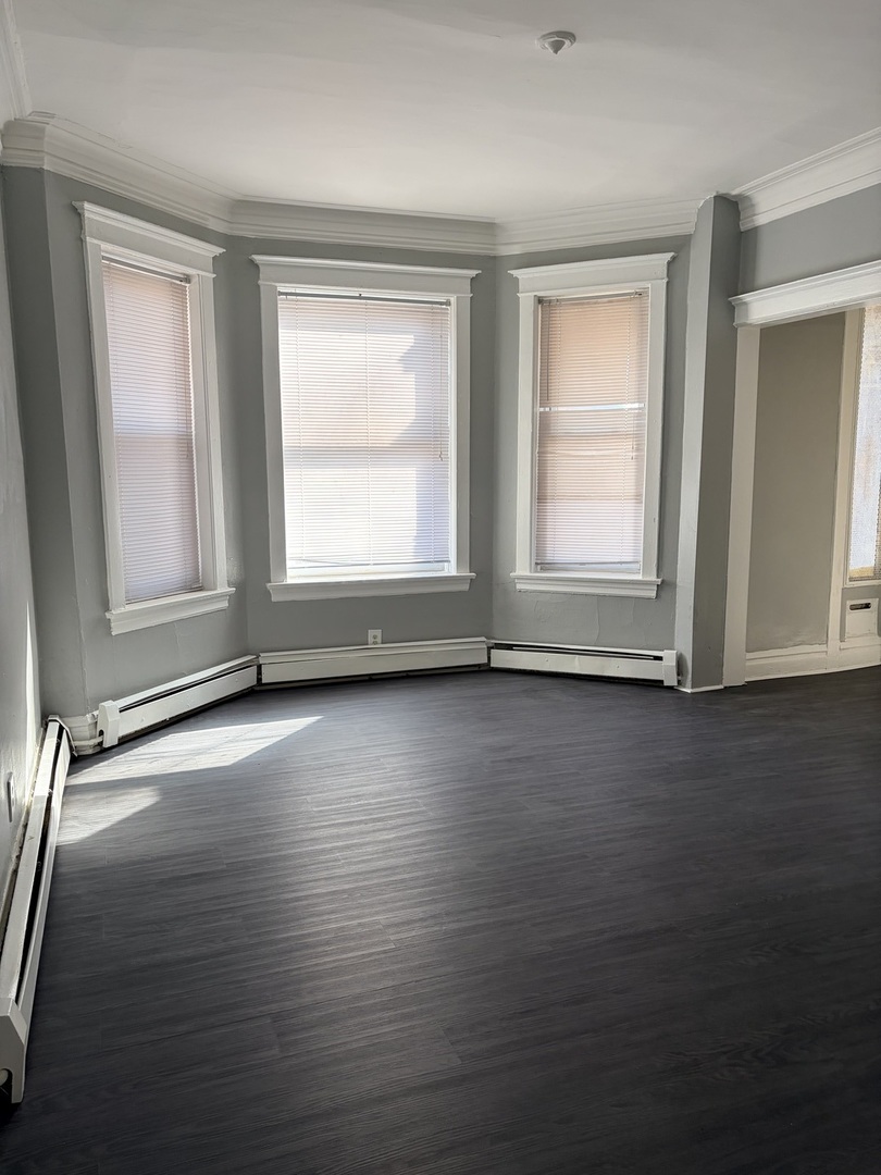7700 South Green Street, Unit 1 Chicago, IL 60620 - Photo 3 of 11 an empty room with wooden floor and windows