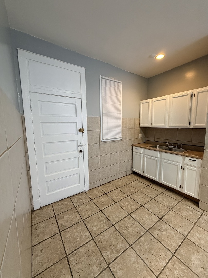 7700 South Green Street, Unit 1 Chicago, IL 60620 - Photo 4 of 11 a kitchen with granite countertop white cabinets and appliances