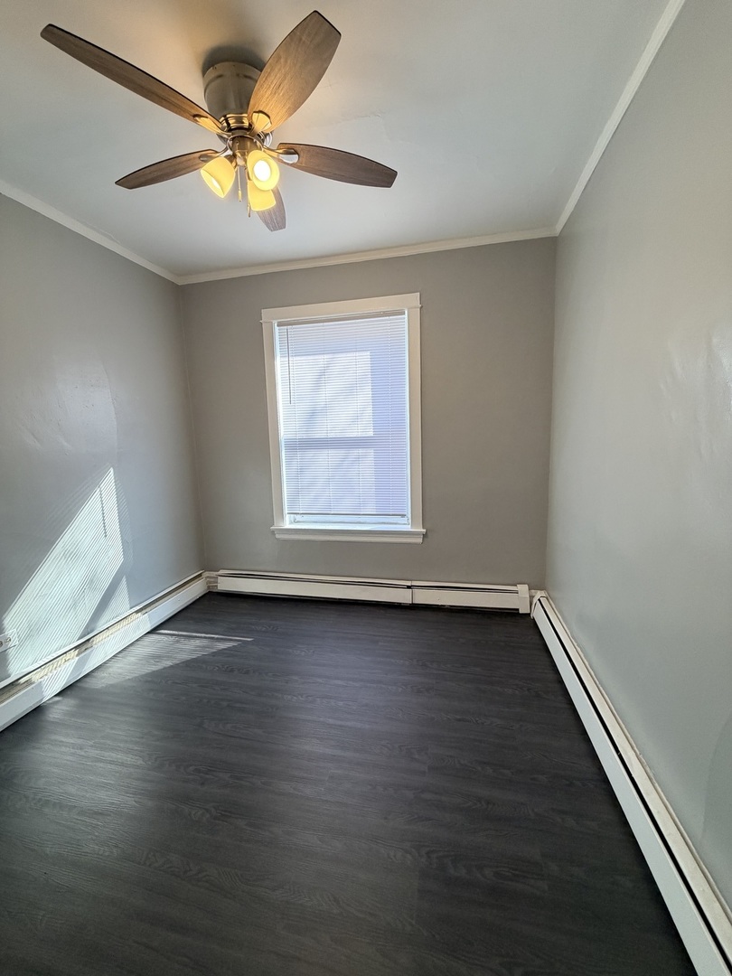 7700 South Green Street, Unit 1 Chicago, IL 60620 - Photo 5 of 11 an empty room with wooden floor and windows