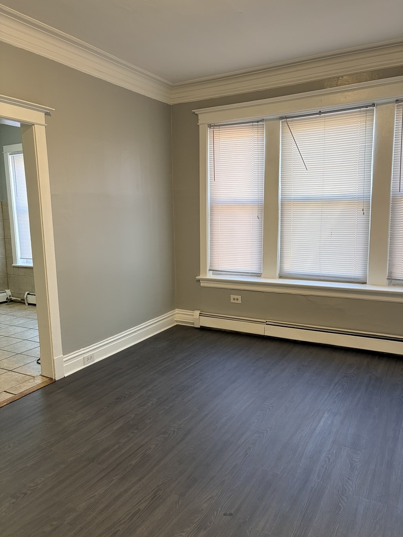 7700 South Green Street, Unit 1 Chicago, IL 60620 - Photo 8 of 11 a view of an empty room with wooden floor and a window