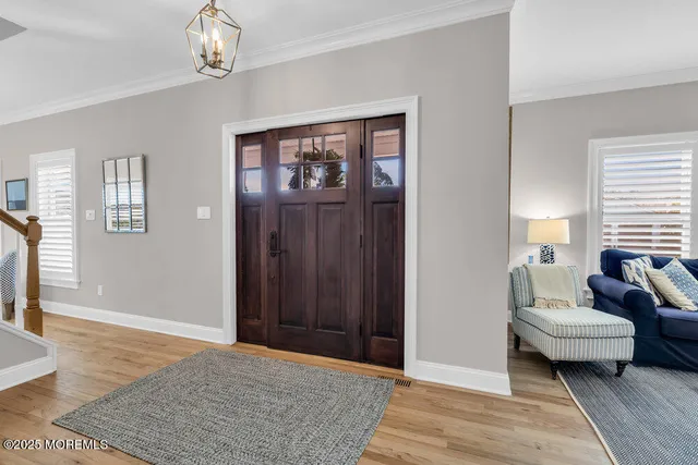 a kitchen with stainless steel appliances kitchen island granite countertop a sink a stove a refrigerator and white cabinets with wooden floor