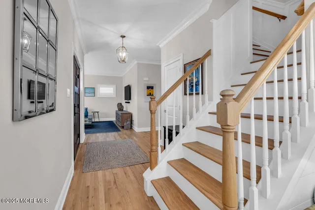 a dining room with wooden floor a chandelier a glass table and chairs