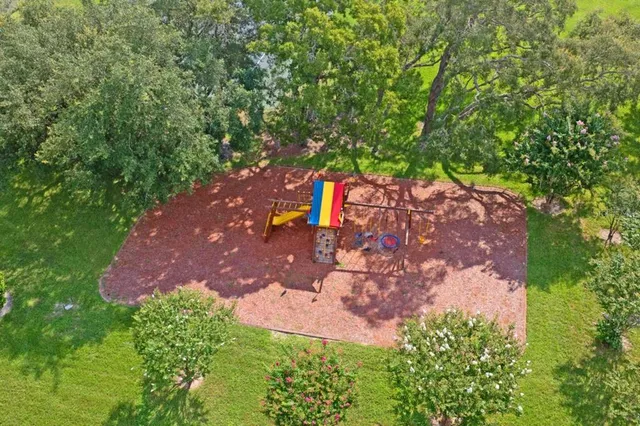 an aerial view of a house with yard and patio