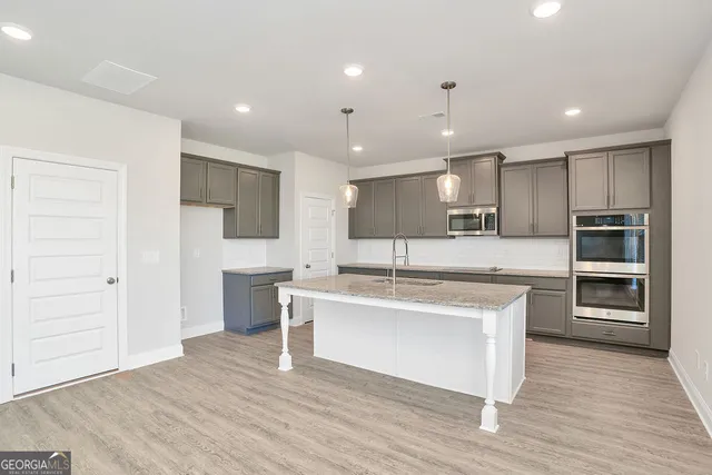 a kitchen with kitchen island a sink and a stove top oven