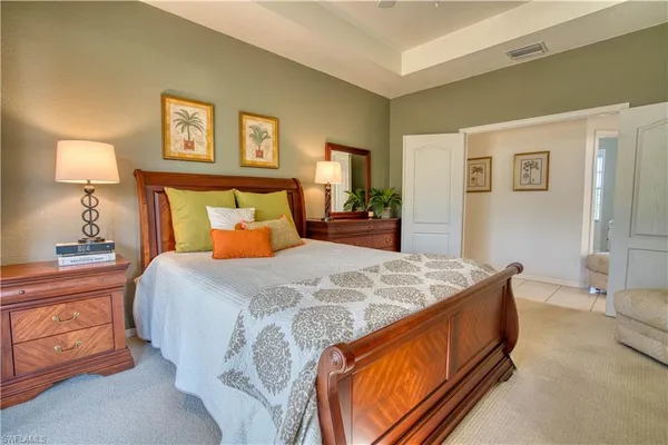 a bed sitting in a bedroom with a lamp