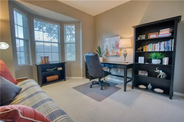 a living room with furniture a bookshelf and a window