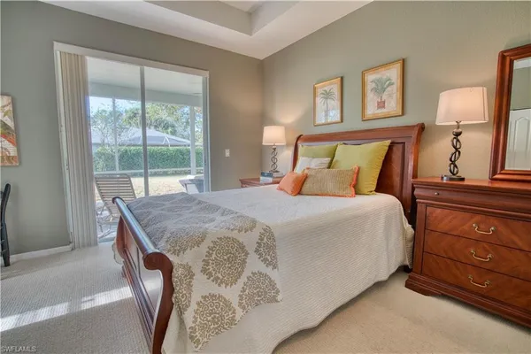 a bedroom with a bed and a dresser next to a window