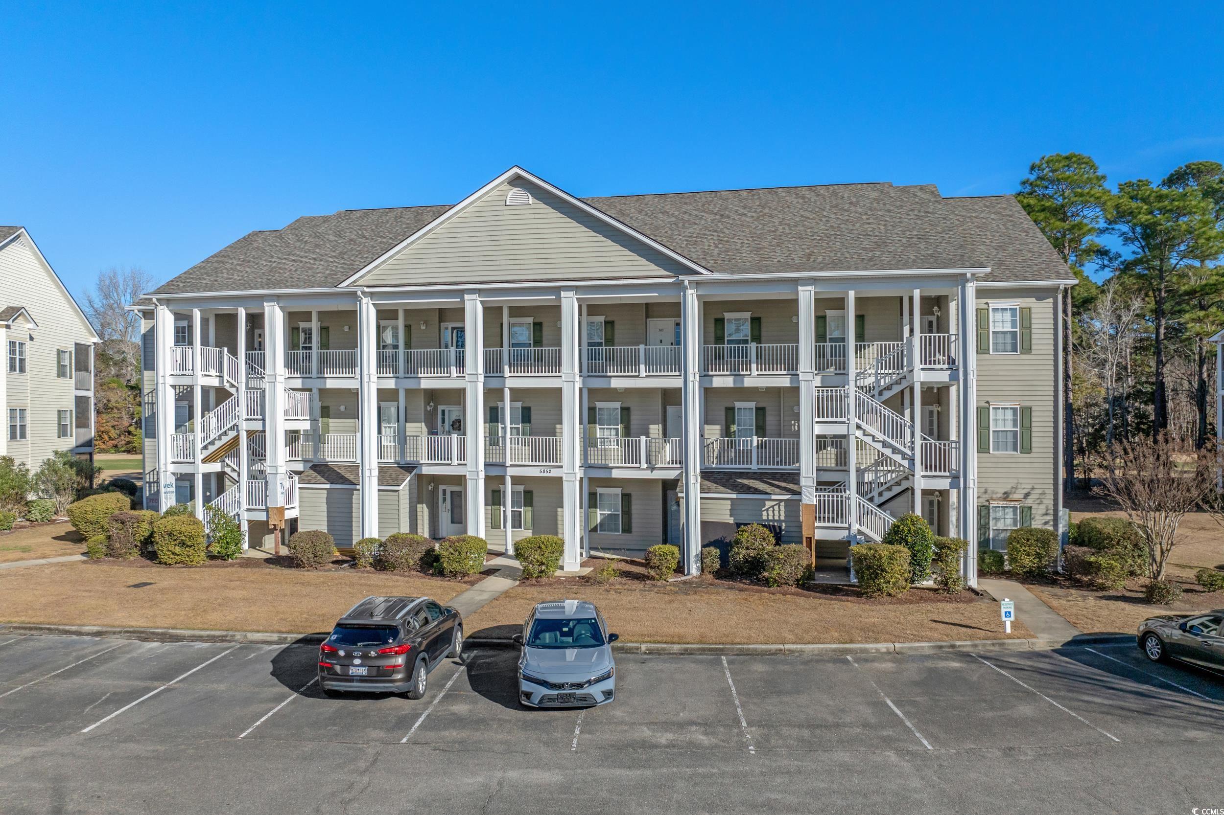 View of apartment building / complex with stairway and uncovered parking