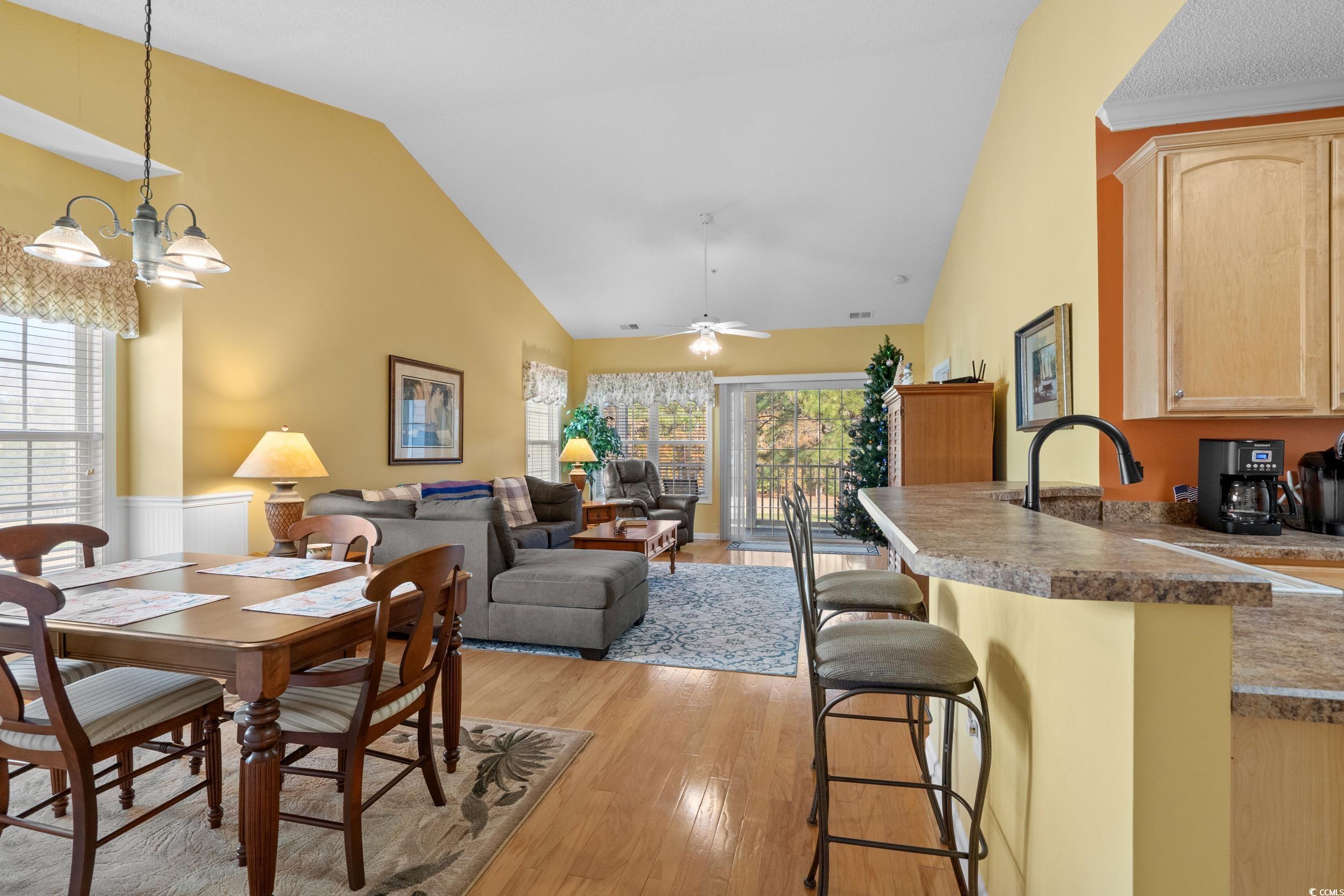 5852 Longwood Drive, Unit 301 Murrells Inlet, SC 29576 - Photo 11 of 35 Dining area with light wood-type flooring, ceiling fan, high vaulted ceiling, and a chandelier