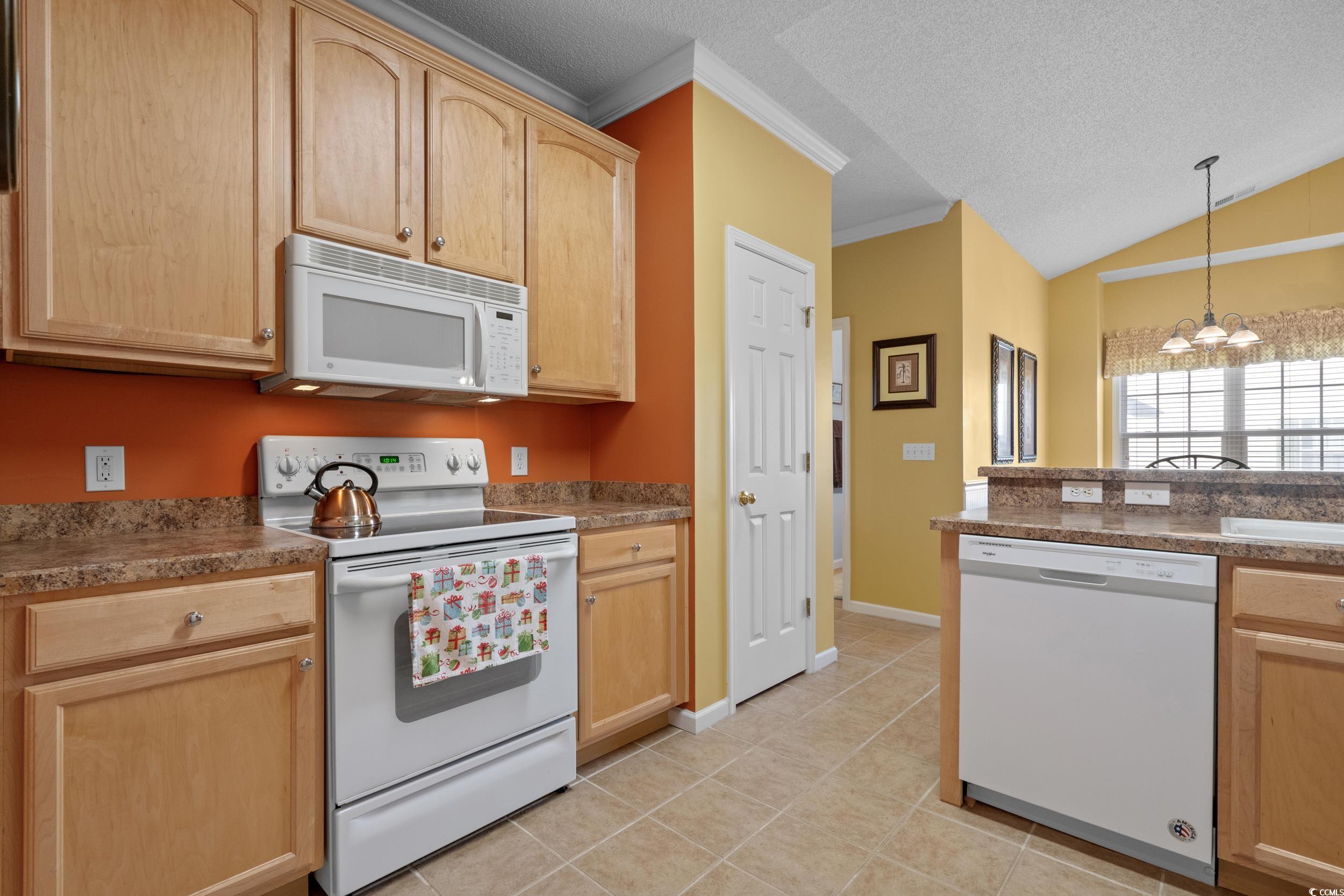 5852 Longwood Drive, Unit 301 Murrells Inlet, SC 29576 - Photo 17 of 35 Kitchen featuring white appliances, light brown cabinetry, ornamental molding, a chandelier, and a textured ceiling
