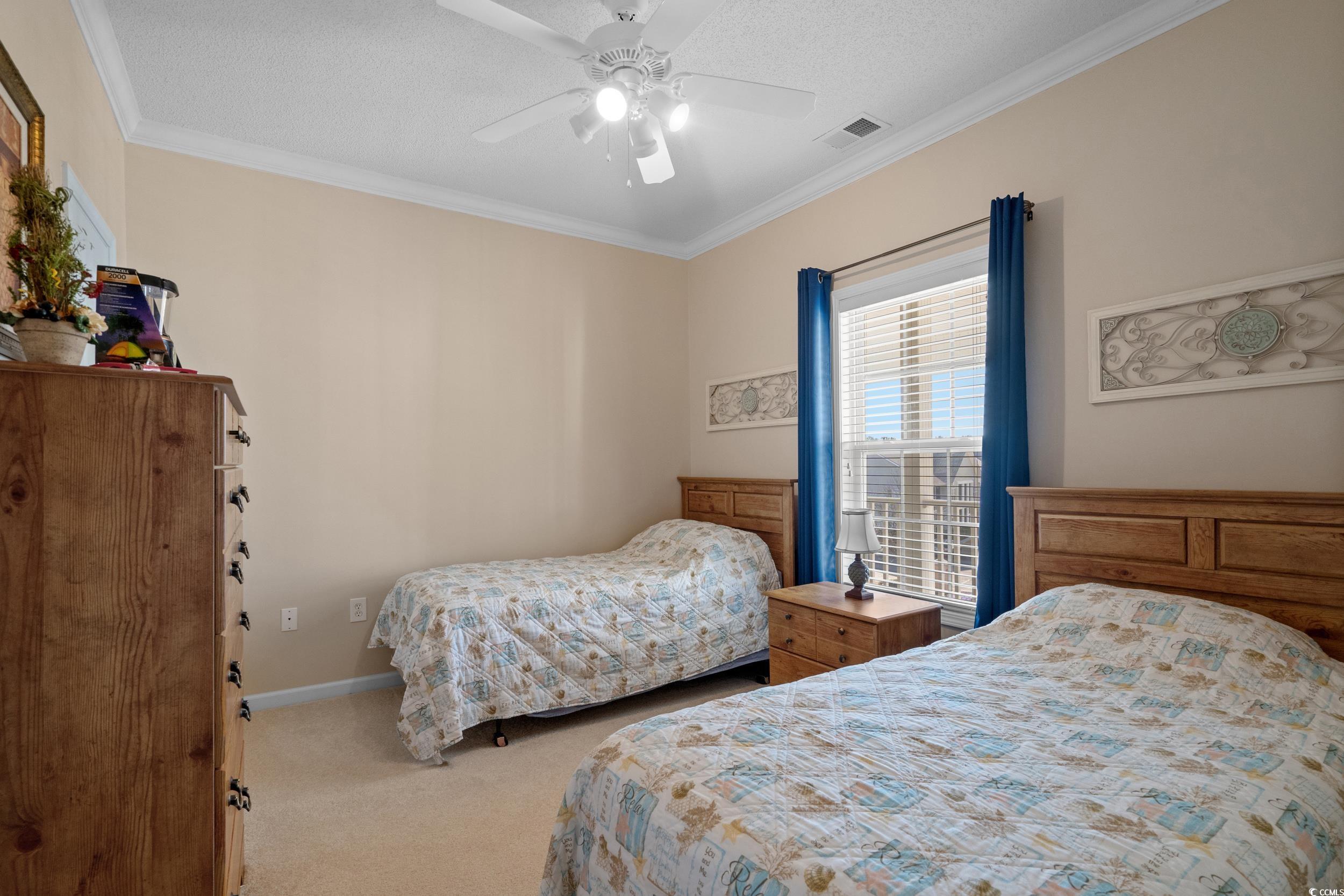 5852 Longwood Drive, Unit 301 Murrells Inlet, SC 29576 - Photo 20 of 35 Bedroom with carpet flooring, ornamental molding, ceiling fan, and a textured ceiling