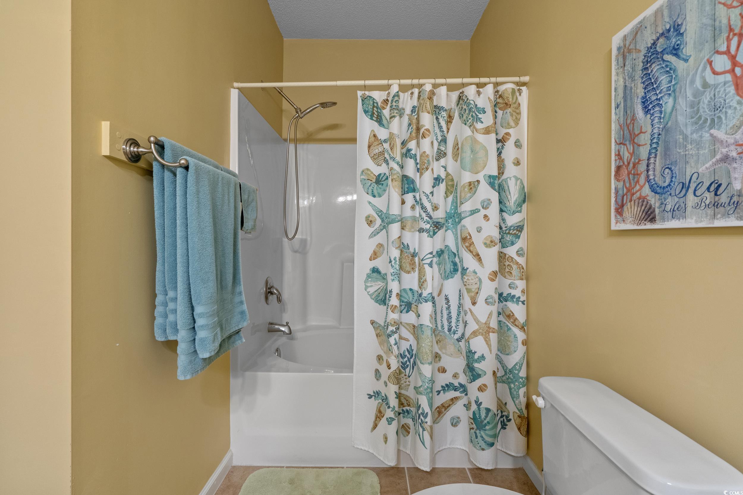 5852 Longwood Drive, Unit 301 Murrells Inlet, SC 29576 - Photo 23 of 35 Bathroom with shower / bath combination with curtain, tile patterned flooring, and a textured ceiling