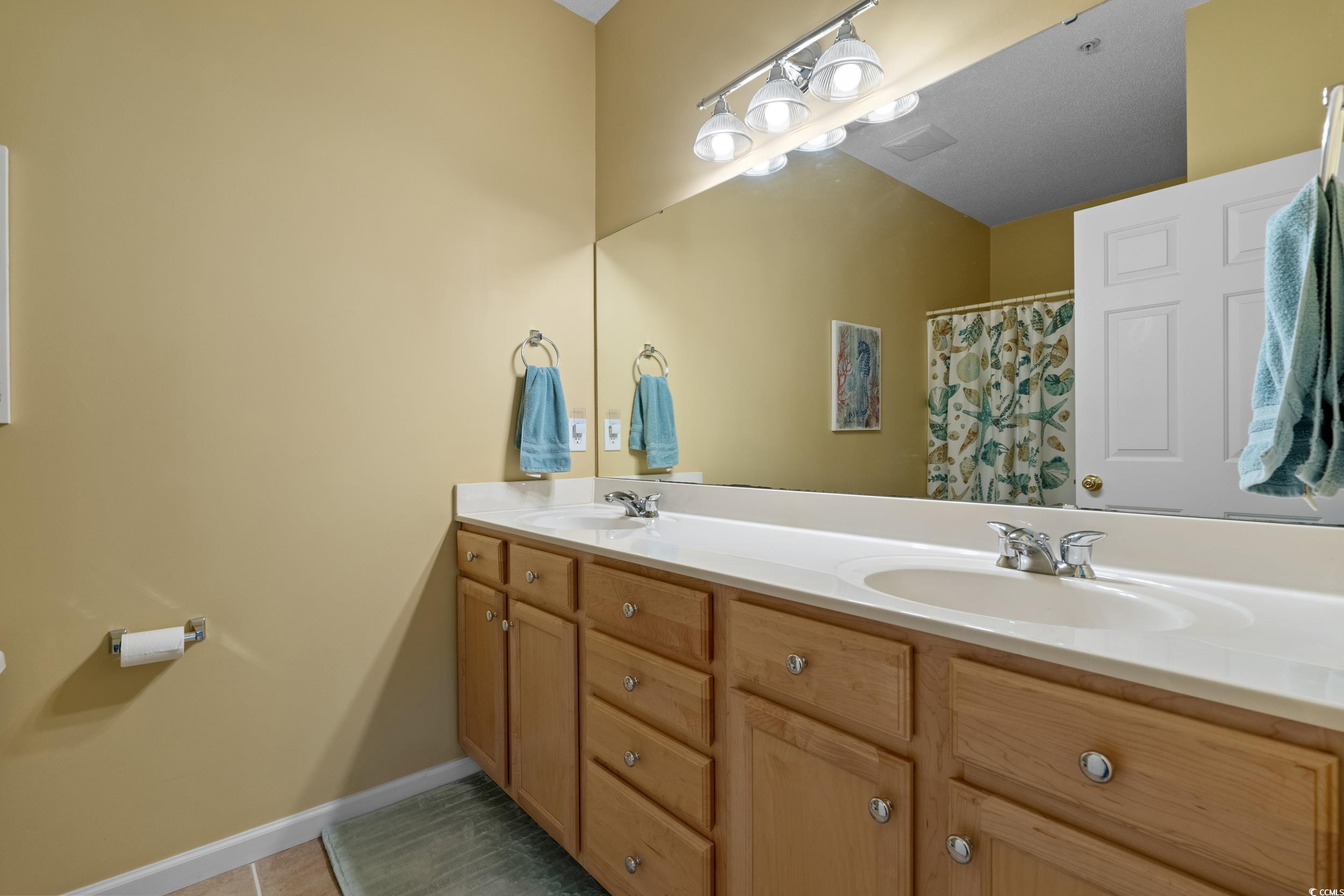 5852 Longwood Drive, Unit 301 Murrells Inlet, SC 29576 - Photo 24 of 35 Full bath featuring double vanity, a shower with shower curtain, and light tile patterned floors