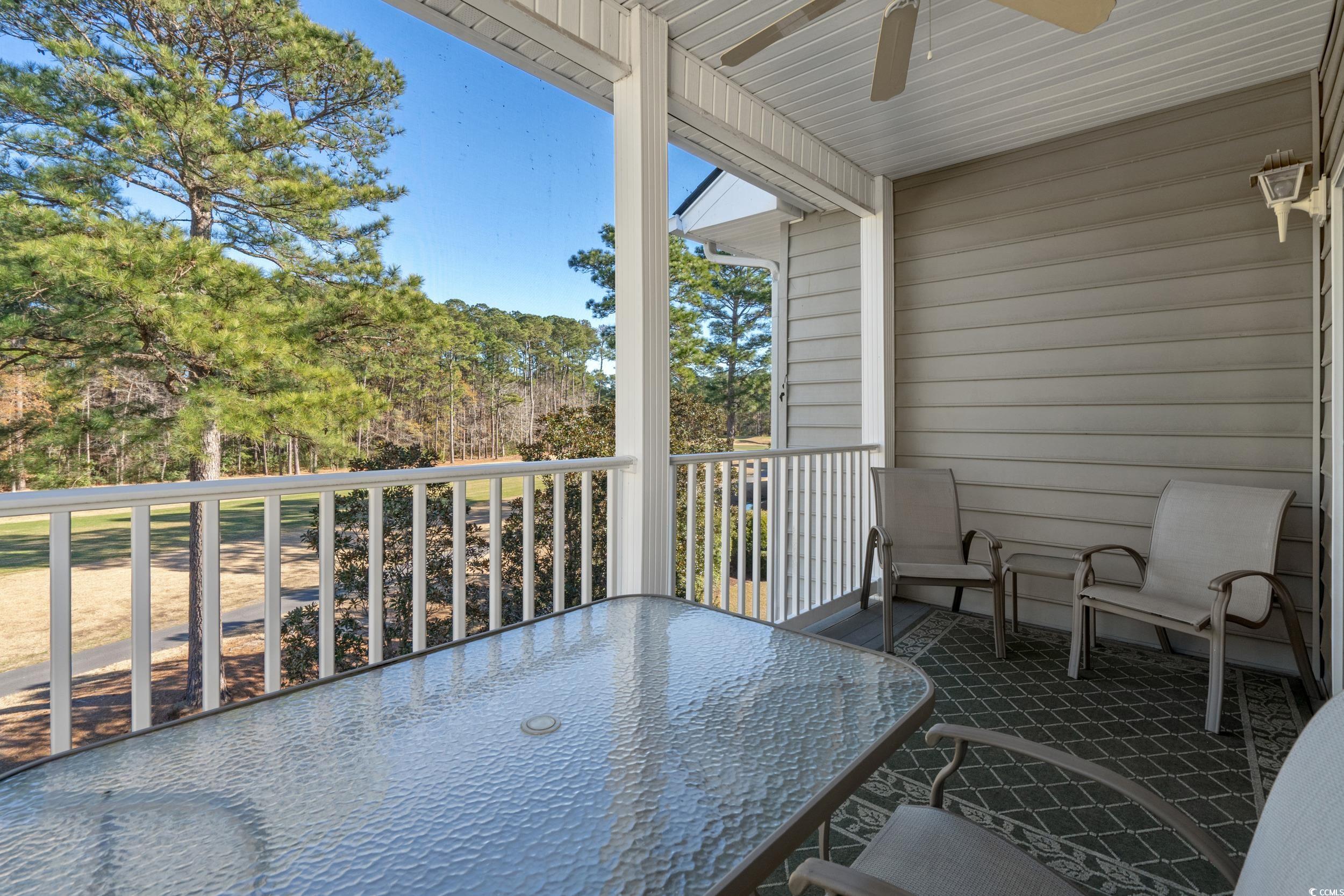 5852 Longwood Drive, Unit 301 Murrells Inlet, SC 29576 - Photo 28 of 35 Balcony featuring ceiling fan, view of scattered trees, and outdoor dining area