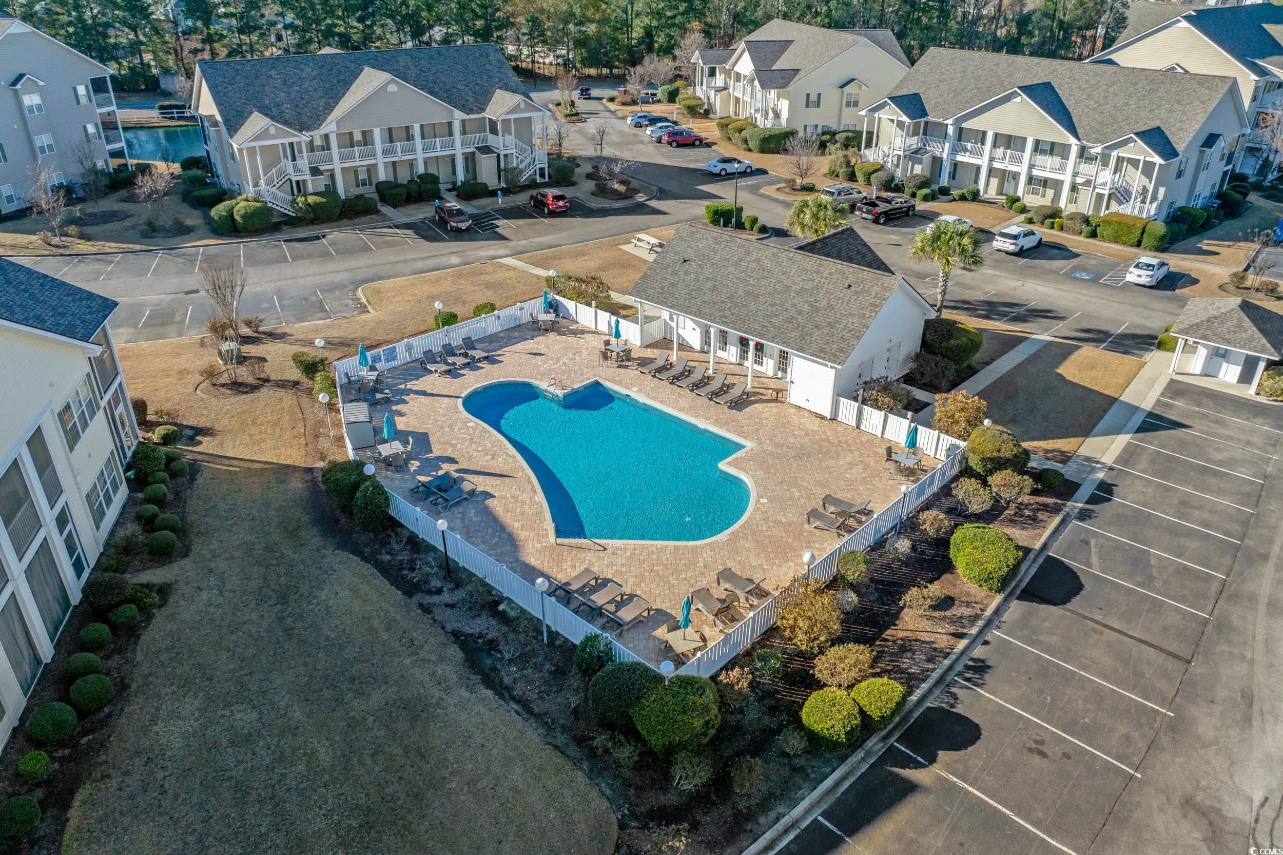 5852 Longwood Drive, Unit 301 Murrells Inlet, SC 29576 - Photo 29 of 35 Aerial perspective of suburban area with a pool area and a tree filled landscape