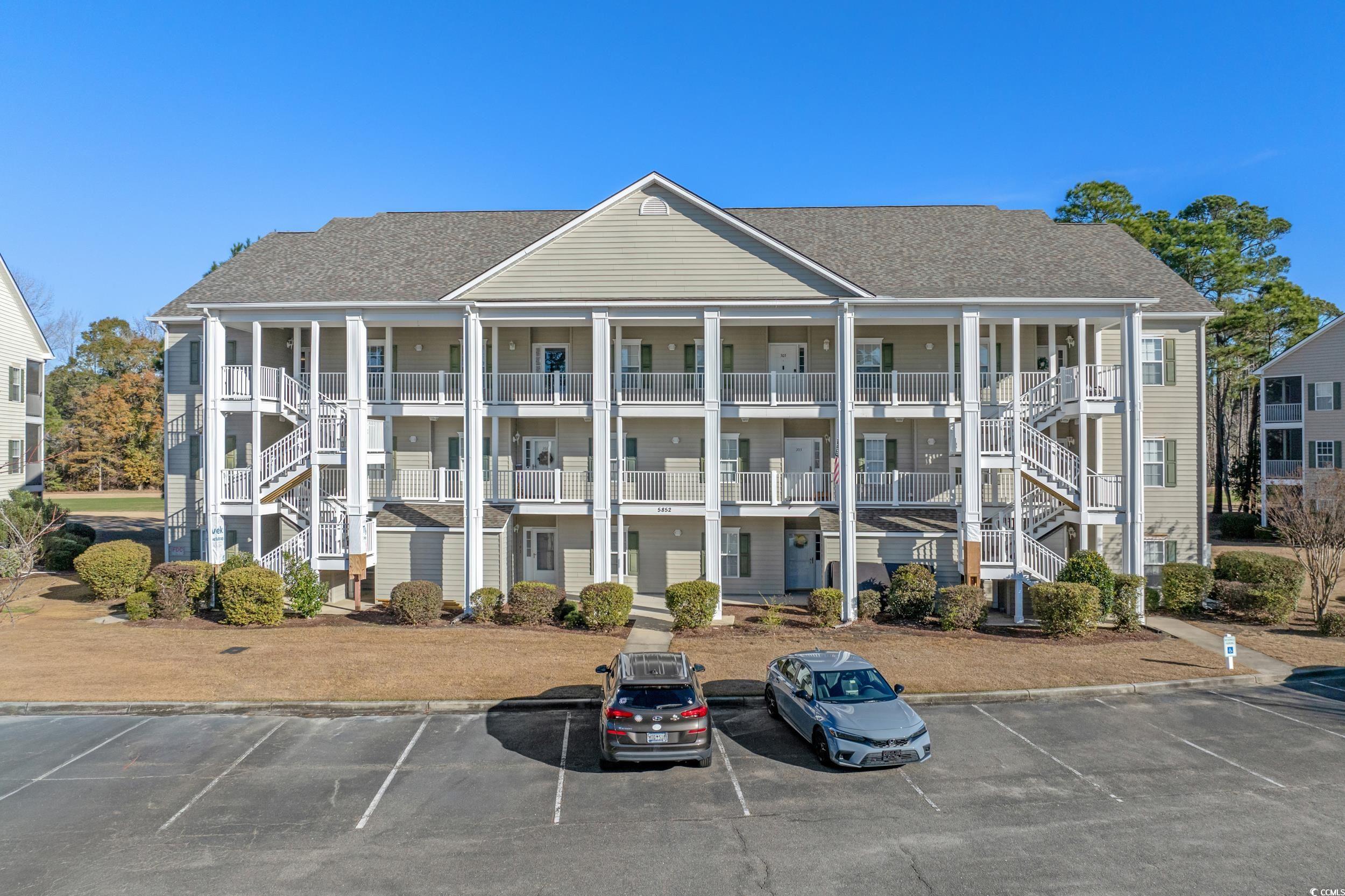 5852 Longwood Drive, Unit 301 Murrells Inlet, SC 29576 - Photo 35 of 35 View of apartment building / complex featuring stairs and uncovered parking