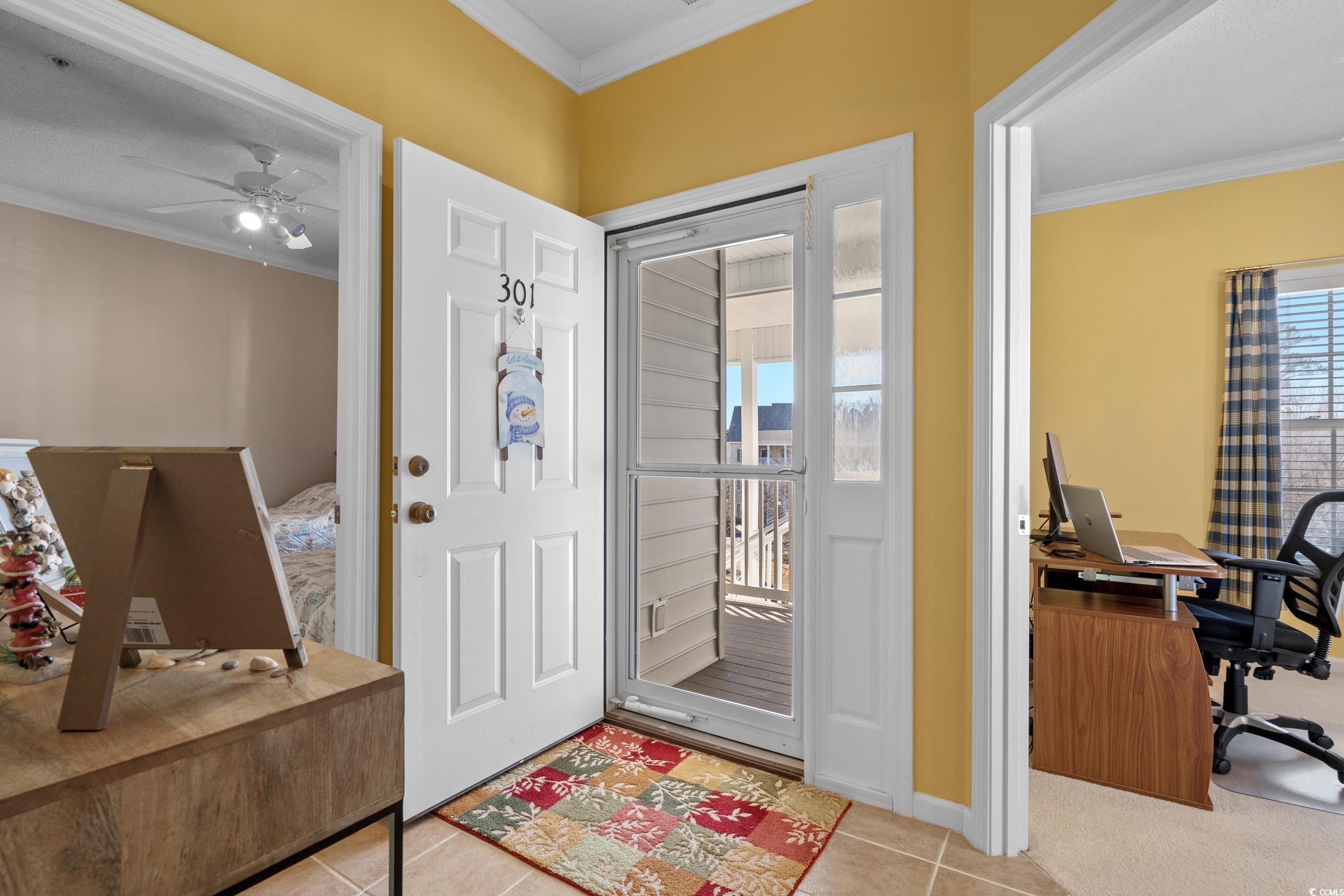 5852 Longwood Drive, Unit 301 Murrells Inlet, SC 29576 - Photo 7 of 35 Foyer with crown molding, a ceiling fan, and light tile patterned flooring