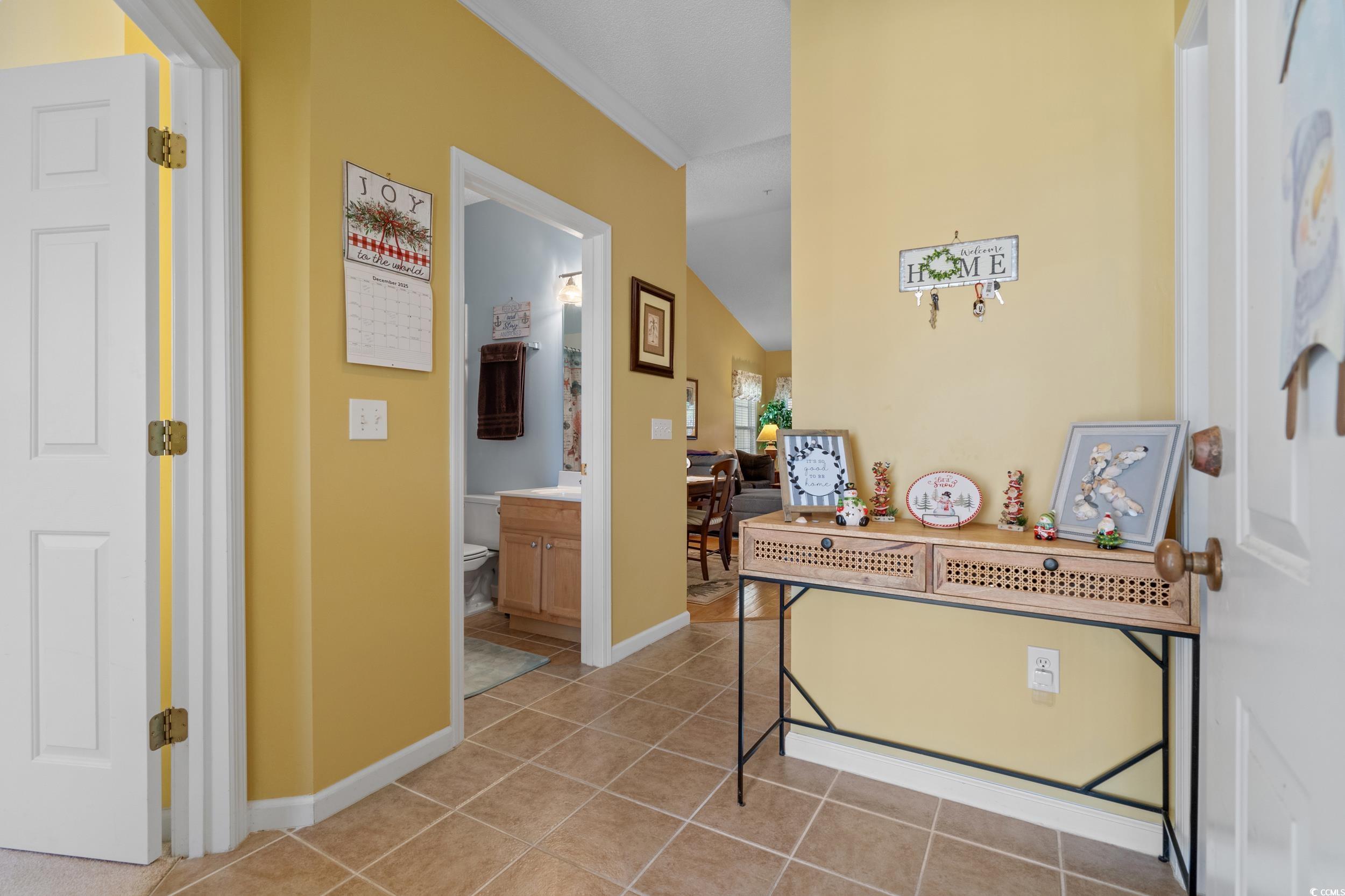 5852 Longwood Drive, Unit 301 Murrells Inlet, SC 29576 - Photo 8 of 35 Corridor featuring light tile patterned flooring, crown molding, and lofted ceiling