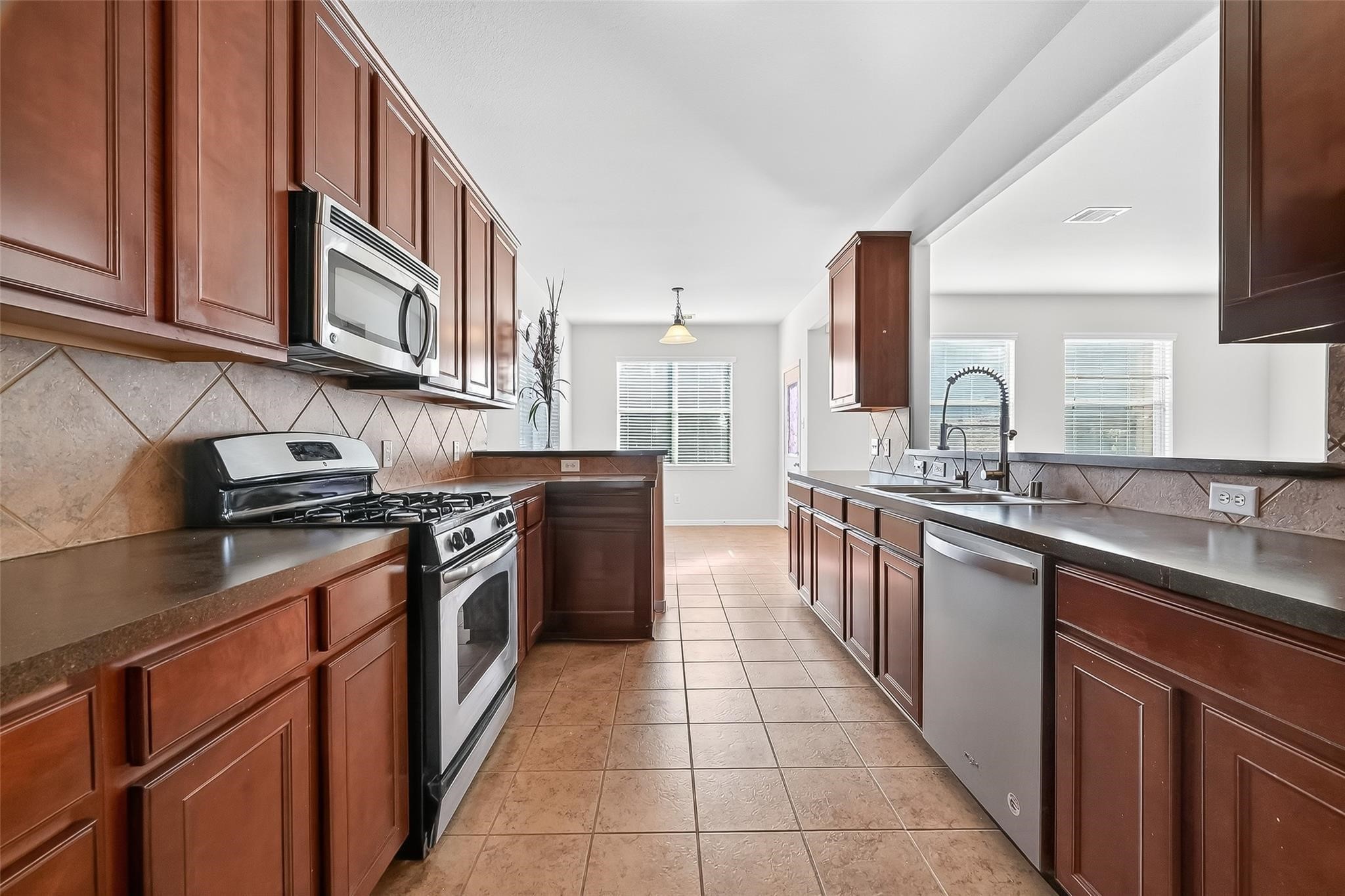 21623 Mid Peak Way Katy, TX 77449 - Photo 11 of 38 a kitchen with stainless steel appliances granite countertop a stove top oven a sink and dishwasher