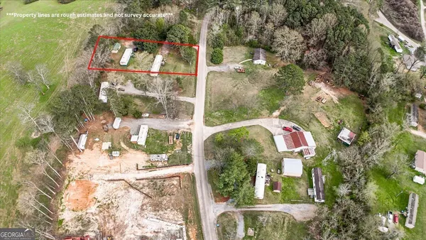 an aerial view of residential houses with outdoor space and trees