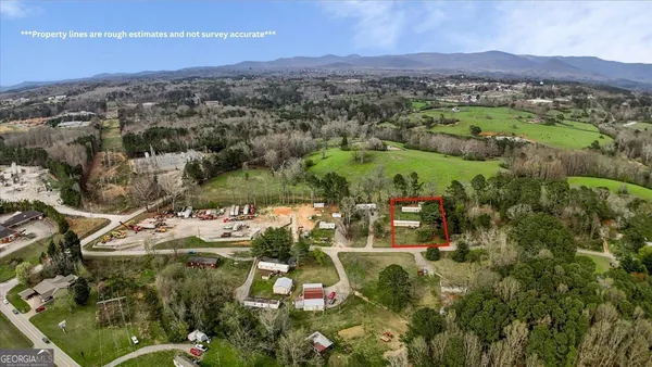 an aerial view of residential houses with outdoor space and trees