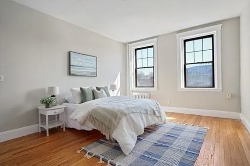 a bedroom with a bed and wooden floor