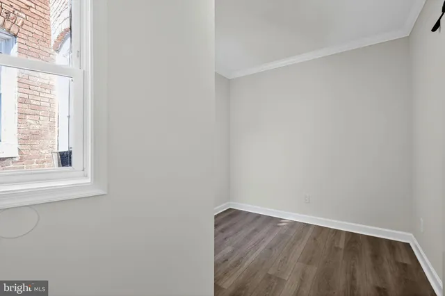 a view of a small space with wooden floor and a window