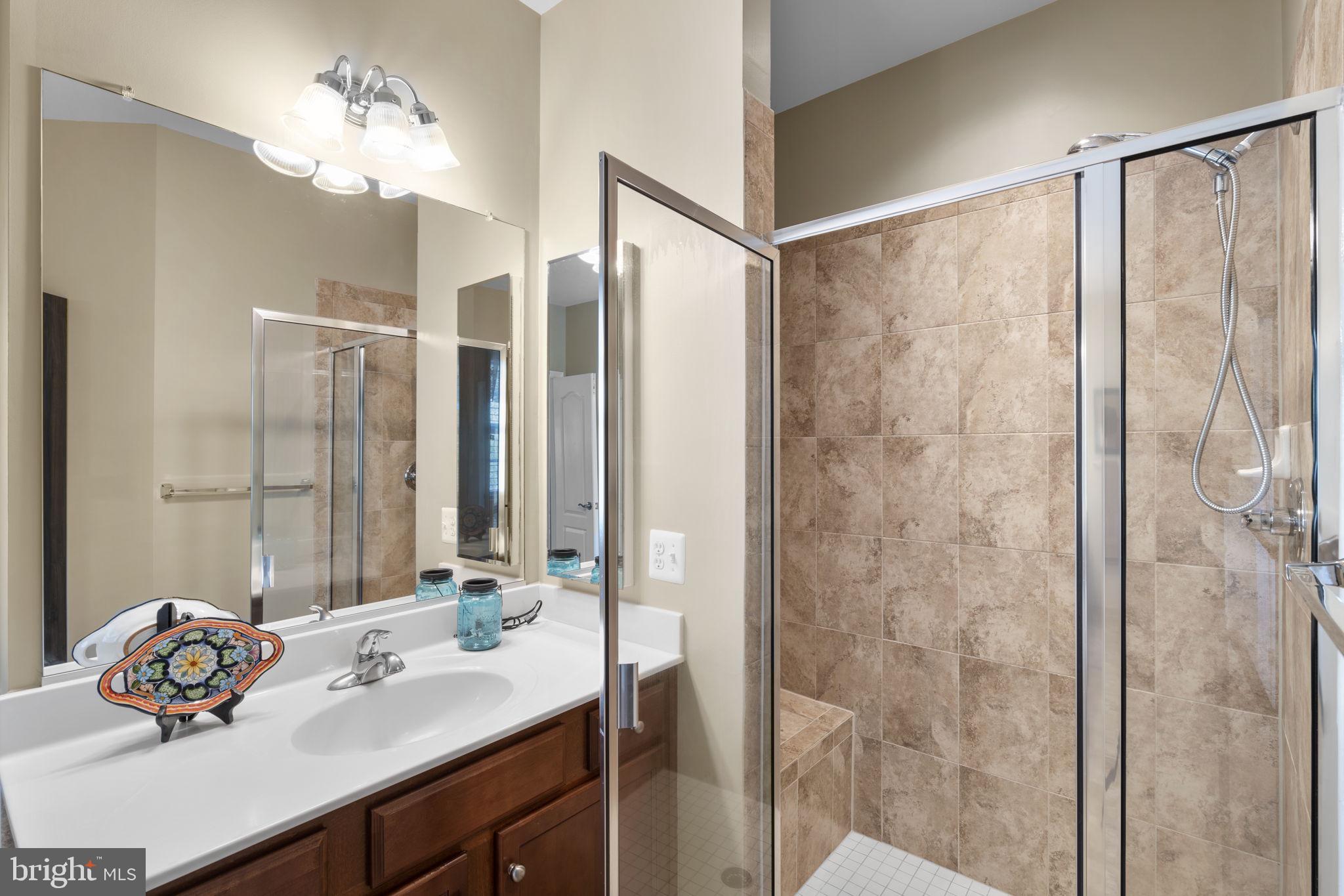 9323 Castle Hill Road Springfield, VA 22153 - Photo 42 of 95 a bathroom with a double vanity sink and a mirror