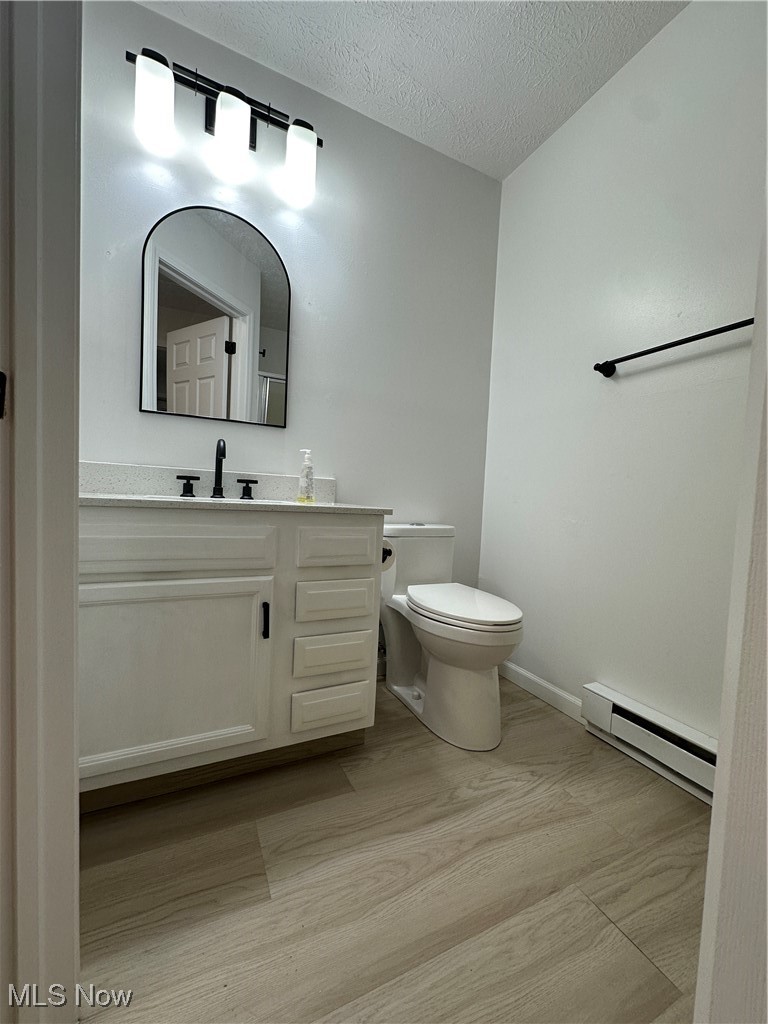 5205 Cline Road, Unit A Kent, OH 44240 - Photo 14 of 23 Bathroom with baseboard heating, light wood-type flooring, vanity, and a textured ceiling