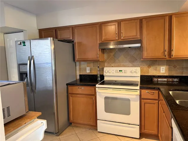 a kitchen with a refrigerator sink and cabinets