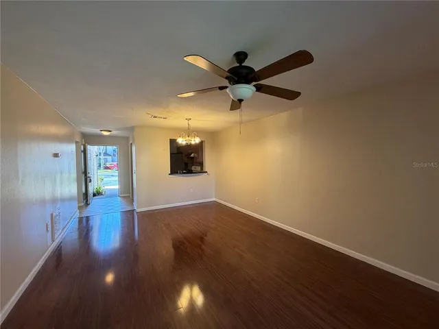 a view of a livingroom with wooden floor and a ceiling fan