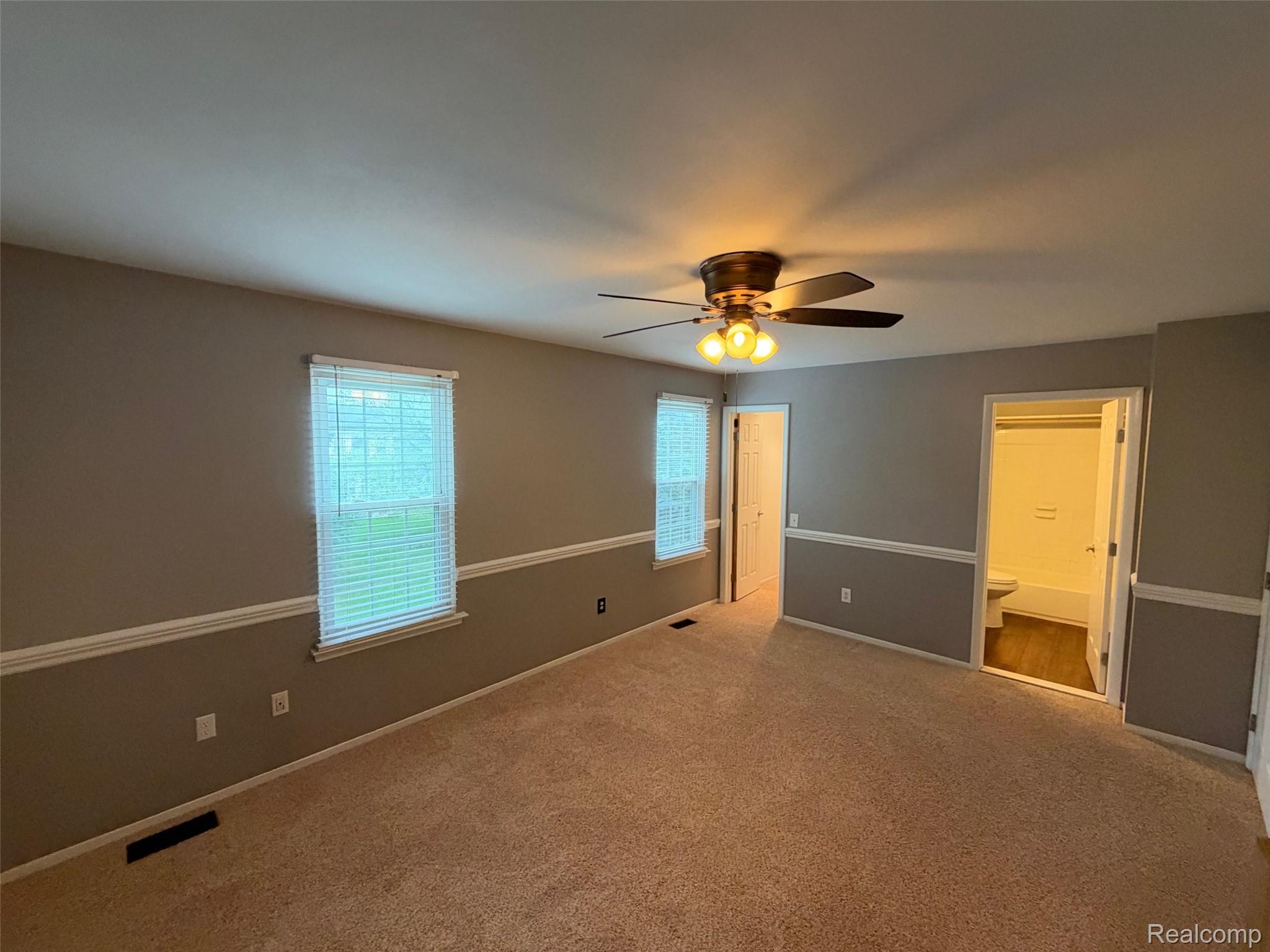24525 Jamestowne Road Novi, MI 48375 - Photo 13 of 20 Carpeted room with crown molding, two windows with blinds, a ceiling fan with integrated lighting, and an adjacent bathroom