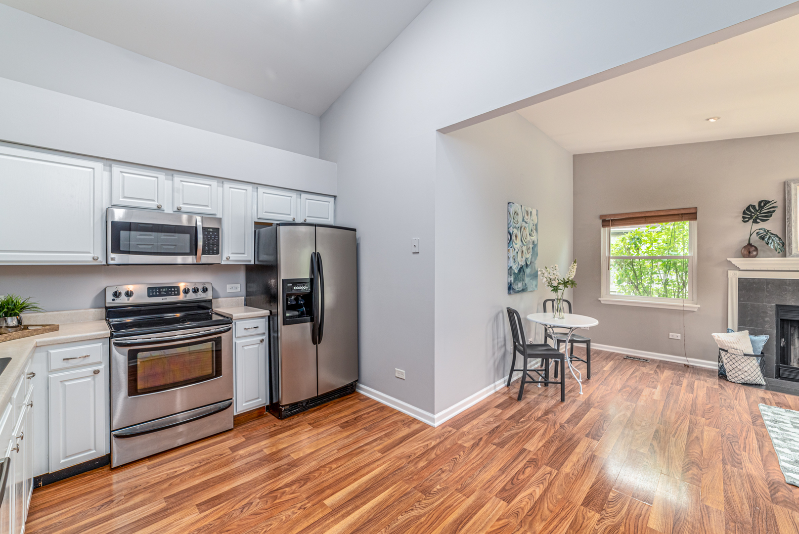 350 Chaparral Circle Elgin, IL 60120 - Photo 3 of 28 a kitchen with granite countertop a refrigerator a stove top oven and wooden floors