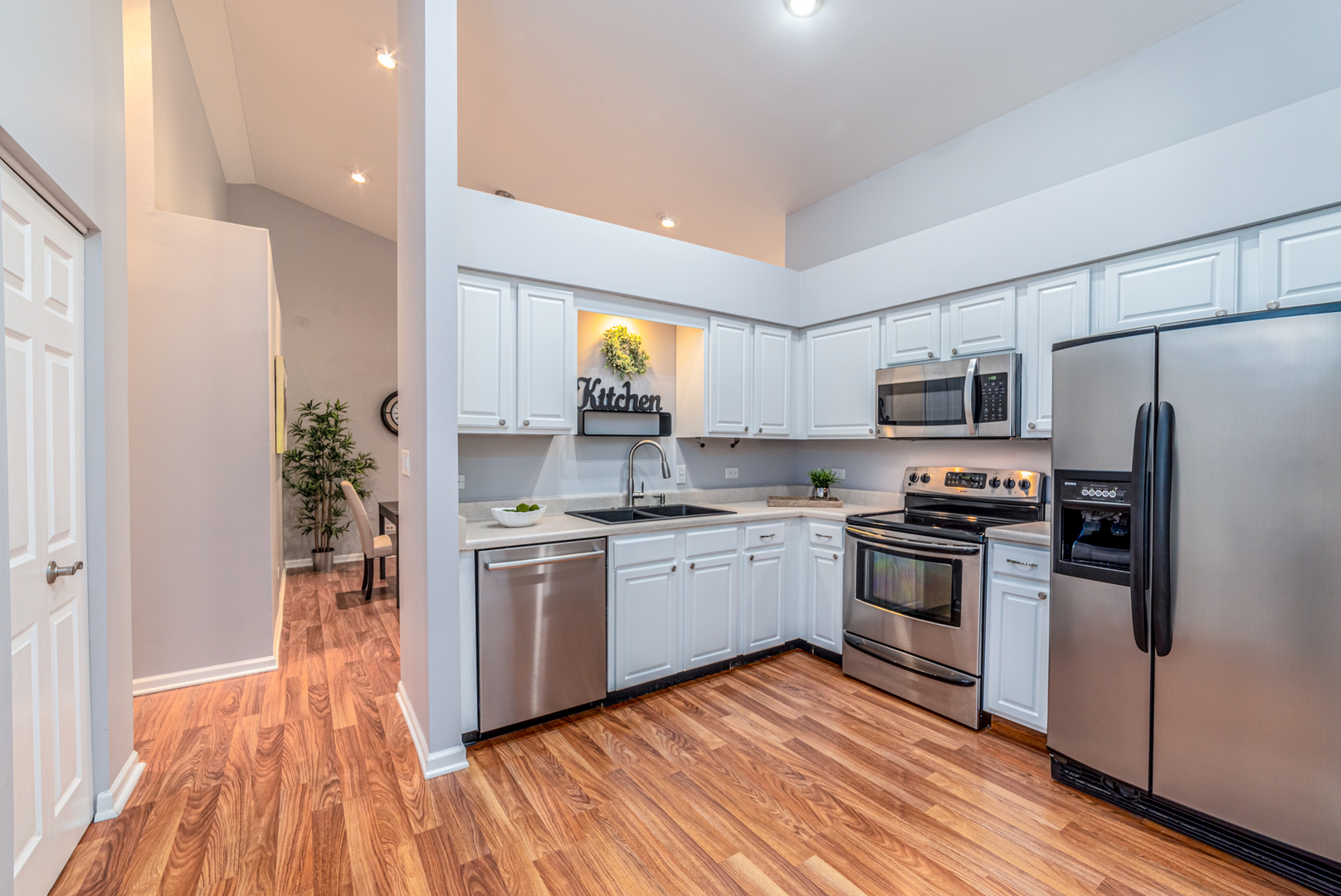350 Chaparral Circle Elgin, IL 60120 - Photo 4 of 28 a kitchen with granite countertop stainless steel appliances a sink cabinets and a wooden floor