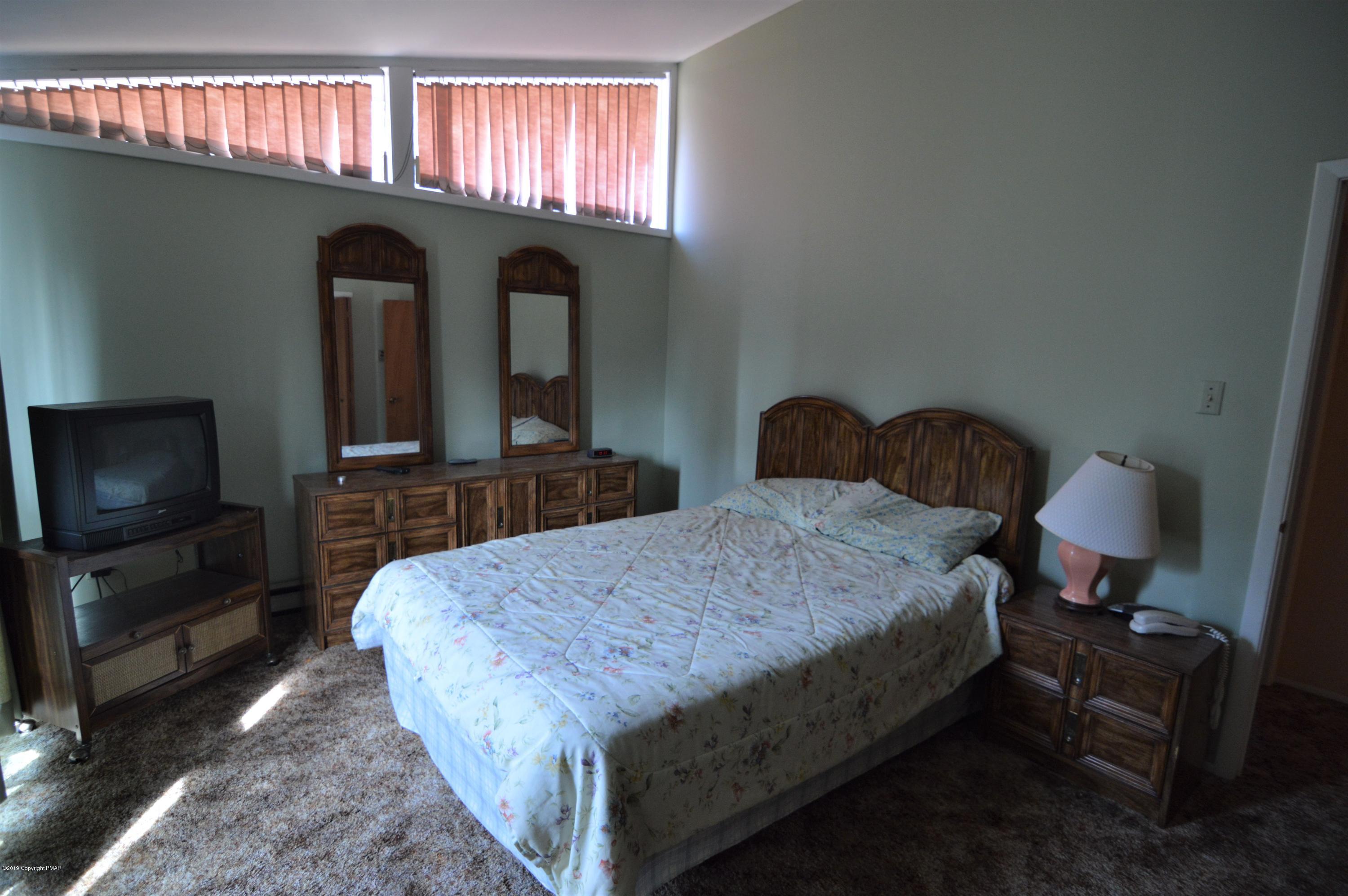 139 Maple Road Blakeslee, PA 18610 - Photo 11 of 29 a bedroom with a bed and a flat tv screen on dresser