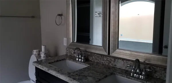 a bathroom with a granite countertop sink and a mirror