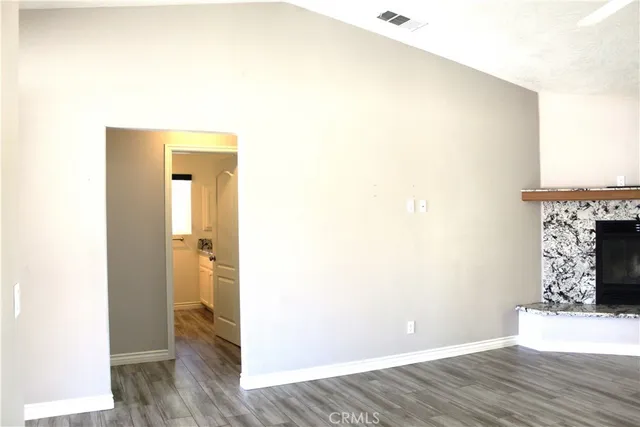 a view of a room with wooden floor and a fireplace
