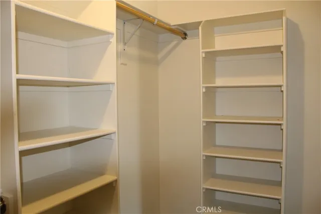 a view of walk in closet with empty racks