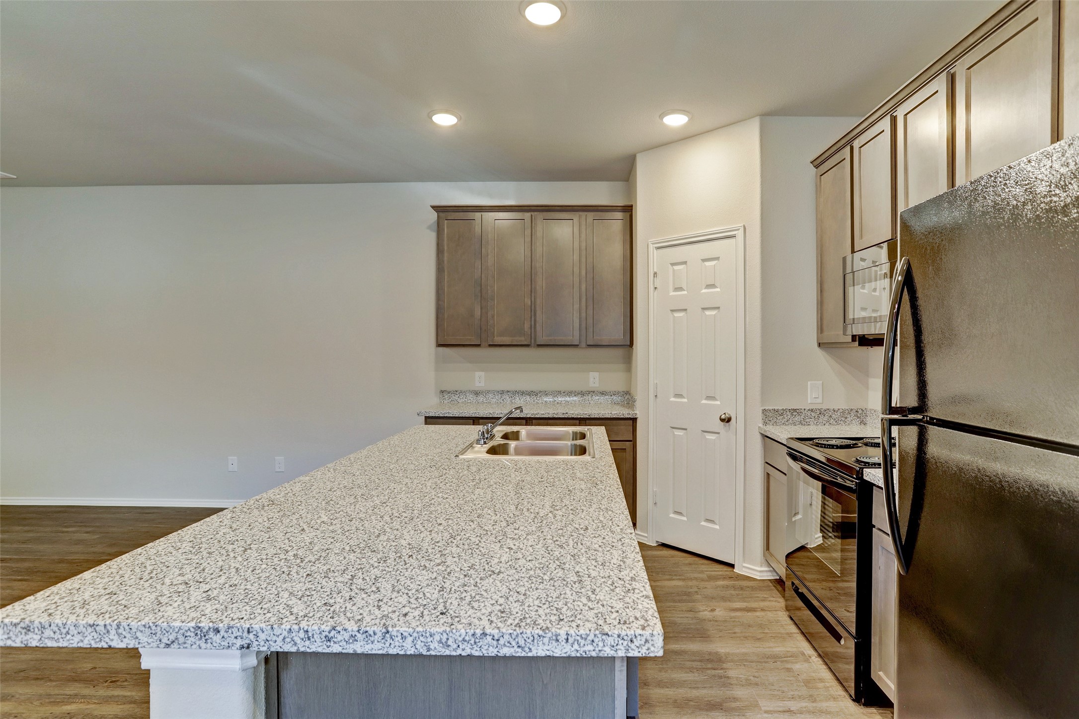 409 South 12th Street, Unit B Conroe, TX 77301 - Photo 5 of 14 This modern kitchen features granite countertops, sleek stainless steel appliances, and ample cabinet space. The open layout and neutral tones create a welcoming atmosphere, ideal for cooking and entertaining.