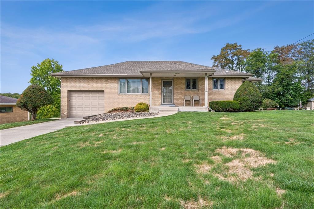 a front view of a house with a garden and yard