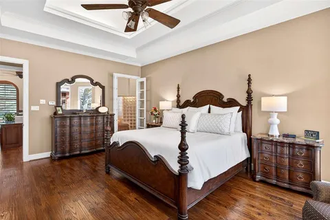 a large bed sitting in a bedroom next to a cabinet and a large window