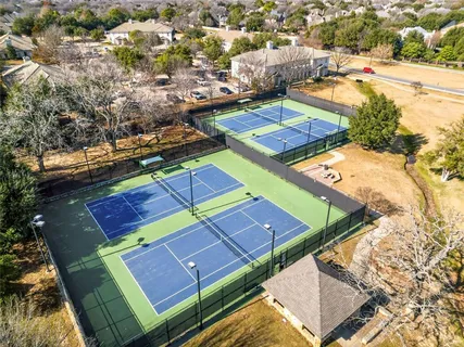 a view of a tennis ground with a ocean view